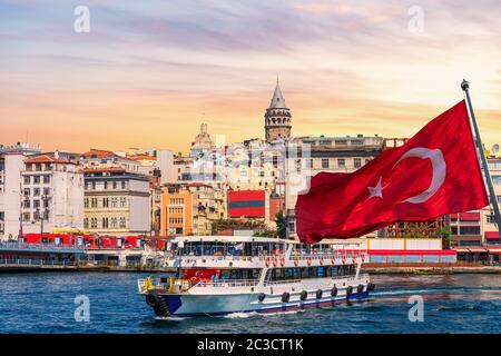 Molo di Karakoy, un traghetto, bandiera turca e la Torre Galata sullo sfondo, Istanbul, Turchia. Foto Stock