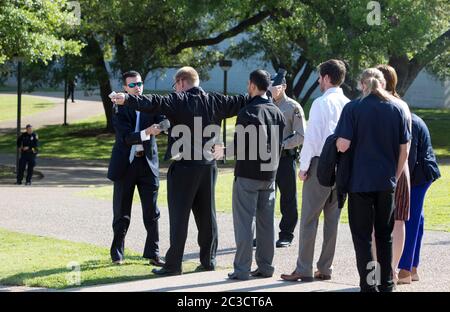 Austin Texas USA, aprile 10 2014: Il team di sicurezza utilizza la bacchetta del metal detector al pubblico e sui media prima di poter entrare nel luogo in cui la Pres. Barack Obama parlerà. ©Marjorie Kamys Cotera/Daemmrich Photography Foto Stock