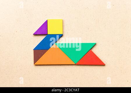 Puzzle tangram colore in forma di cigno o anatra su sfondo di legno Foto Stock