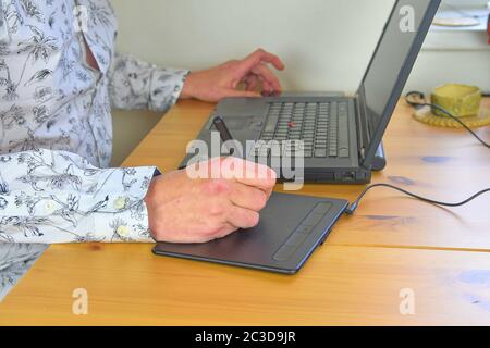 Designer grafico che lavora su tablet digitale. Il luogo di lavoro del designer, le mani degli uomini lavorano su un tablet grafico. Primo piano Foto Stock
