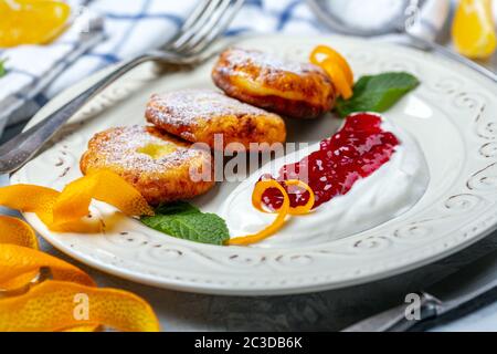 Frittelle di formaggio cottage con panna acida e marmellata. Foto Stock