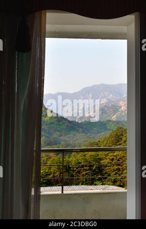 Diamond Mountains, Corea del Nord - 4 maggio 2019: Vista sul paesaggio montano attraverso la porta con balcone aperto nel Kumgangsan Hotel all'alba. Una prima classe Foto Stock