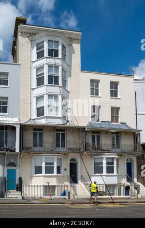 Ramsgate, UK - Giugno 19 2020 UN pulitore di acqua pura con un palo molto lungo affronta il 5 ° piano di una casa di città d'epoca. Foto Stock