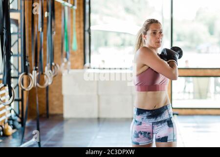 Giovane donna sportiva si sta riscaldando per l'esercizio di boxe Foto Stock