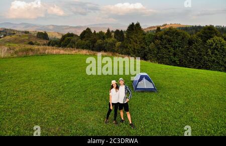 Vista aerea di coppia di amanti trascorrere il tempo insieme lontano dal trambusto della città all'alba in campeggio montagna giorno Foto Stock