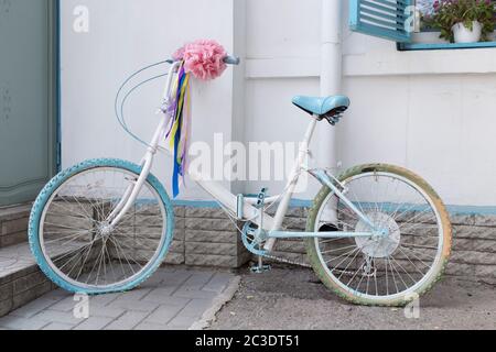 Bicicletta d'epoca su sfondo bianco. Con arco rosa. Foto Stock