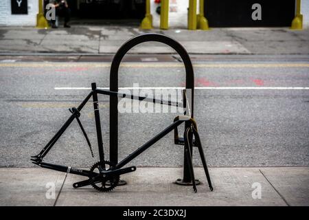 Un telaio di bicicletta abbandonato e derelict bloccato ad una rastrelliera nel quartiere di New York di Chelsea giovedì 11 giugno 2020. (© Richard B. Levine) Foto Stock