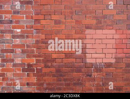 una vecchia parete esterna riparata con patched fatta di mattoni rossi Foto Stock