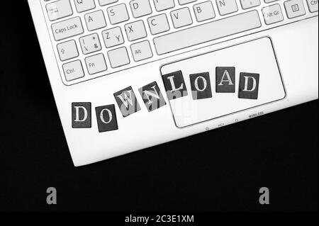 Download - tastiera di computer portatile con lettere. Caricamento, condivisione e download di dati tramite il sito Web Internet. Pirateria illegale Foto Stock