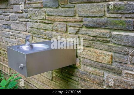 Foto orizzontale di una fontana all'aperto nel Great Smoky Mountains National Park, montata su un muro di pietra. Foto Stock