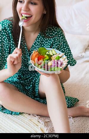 Donna sorridente con ciotola di alimentazione Foto Stock