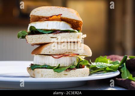 Panino di ciabatta con formaggio di capra fresco, pancetta e spinaci. Foto Stock