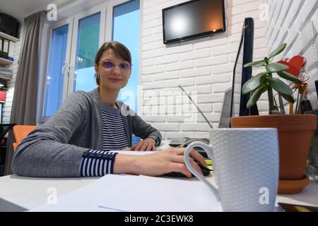 Ragazza lavora al computer da remoto a casa Foto Stock