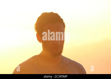 Tenerife, Spagna - 12/19/17: Un uomo bearded che guarda in lontananza con un tramonto arancione Foto Stock