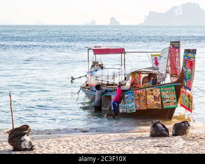 Krabi, Thailandia - 14 febbraio 2019: Mercato galleggiante. Vendita di cibo e bevande da imbarcazioni. Menu a poppa della nave. Raccolta tre sacchi di spazzatura sulla spiaggia, finire la vendita. Andare a galleggiare via Foto Stock