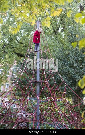Ragazza (7) su telaio di arrampicata su corda, Kiel, Schleswig-Holstein, Germania Foto Stock