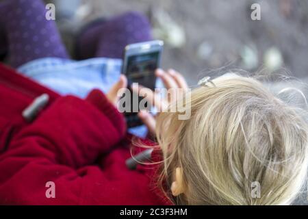 Ragazza (7) che usa smartphone, Kiel, Schleswig-Holstein, Germania Foto Stock