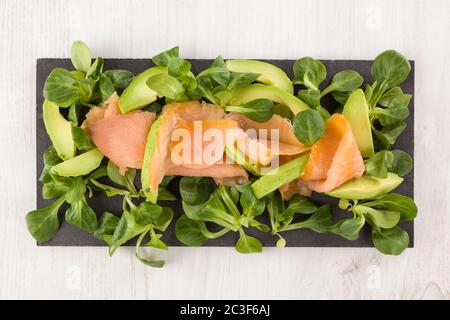 Fette di salmone affumicato, foglie di lattuga e avocado. Vitamine Omega. Foto Stock