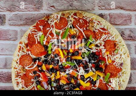 Pizza con olive nere, pepperoni, salsiccia, pepe e formaggio. Tutto pizza. Foto Stock