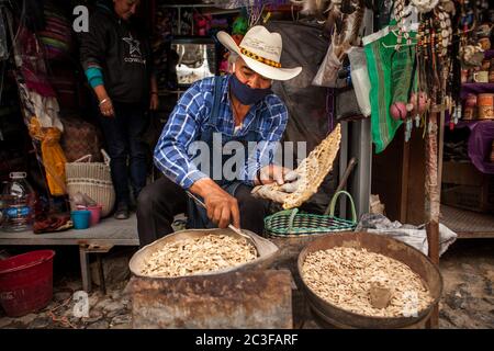 Real De Catorce, Messico. 13 Giugno 2020. Un uomo che indossa una maschera facciale come misura preventiva vende semi di girasole in un piccolo negozio durante la riapertura delle imprese dopo tre mesi di blocco a causa della pandemia del coronavirus. Credit: Antonio Cascio/SOPA Images/ZUMA Wire/Alamy Live News Foto Stock