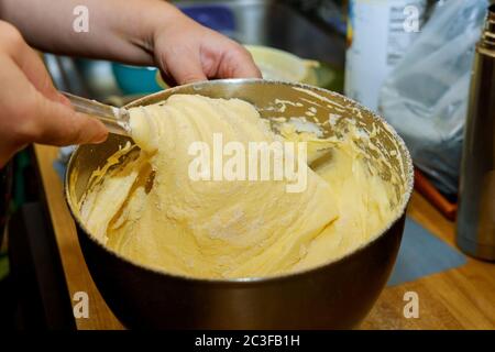 Mescolare l'impasto con le mani per la torta o la pan di Spagna. Foto Stock