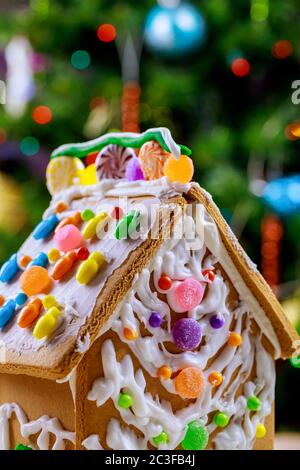 Casa decorata con pan di zenzero di fronte a un albero di Natale luci. Foto Stock