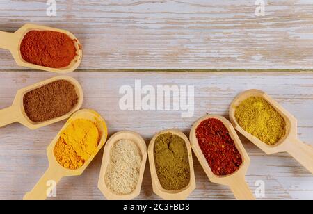 Assortimento di spezie ed erbe colorate nelle sessole di legno. Foto Stock