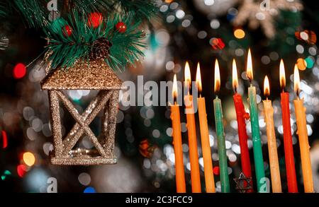 Festa ebraica. Hanukkah su menorah con candele brucianti per sfondo scintillante con luci colorate sfocate. Foto Stock