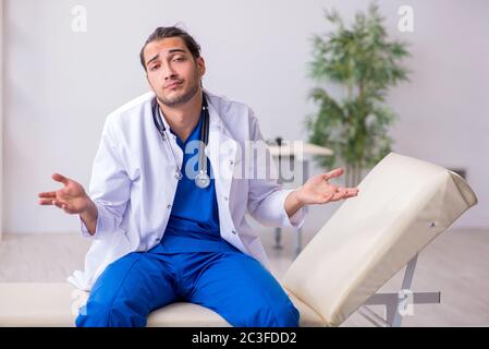 Giovane medico di sesso maschile stanco dopo il turno di notte Foto Stock