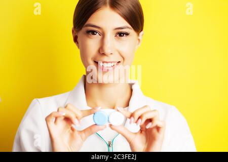 L'oftalmologo tiene un contenitore con lenti a contatto vicino agli occhi Foto Stock