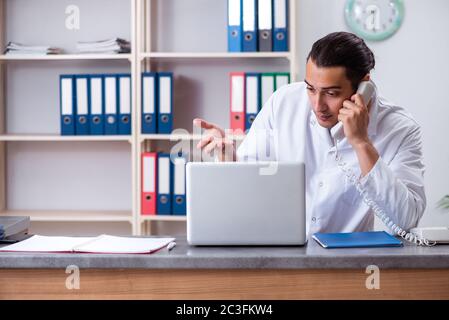 Giovane maschio medico presso la reception in ospedale Foto Stock