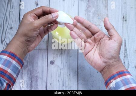 Mani dell'uomo con gel igienizzante per le mani, vista dall'alto Foto Stock