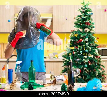 Giovane uomo cucina pulizia dopo la festa di Natale Foto Stock