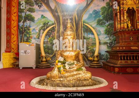 Phayao, Thailandia - 31 dicembre 2019: Statua del Buddha d'oro su albero Pittura sfondo in Wat Phra Nang DIN o tempio Phra Nang DIN a Chiang Kham Distretto P Foto Stock