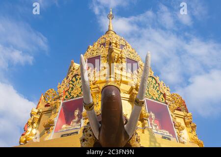 Phayao, Thailandia - 31 dicembre 2019: Statua dell'Elefante marrone e Pagoda dell'Oro o Stupa su sfondo Blue Sky in Wat Phra Nang DIN o Tempio Phra Nang DIN a. Foto Stock