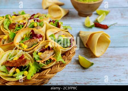 Tortillas al forno coni con lattuga e carne su sfondo di legno primo piano. Foto Stock