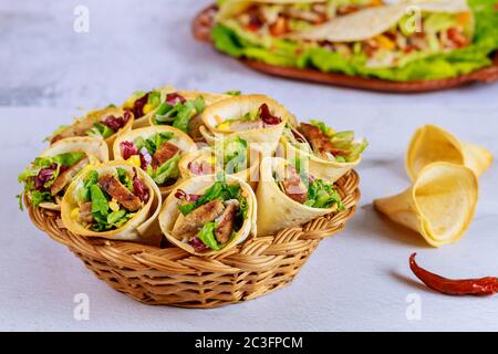 Tortilla di cibo latino con carne e insalata su cesto marrone. Foto Stock