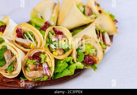 Tortillas al forno coni con lattuga e carne su sfondo bianco primo piano. Foto Stock