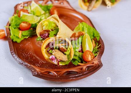 Tortilla di cibo latino con carne e insalata su vassoio marrone Foto Stock