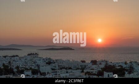 il sole tramonta dietro la città di chora sull'isola di mykonos Foto Stock