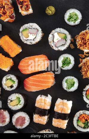 Set di sushi grande, sparato sopra un fondo nero. Molti maki, nigiri e rotoli diversi Foto Stock