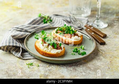 Canape o crostini con baguette tostate, formaggio caserario, confettura di fichi Foto Stock