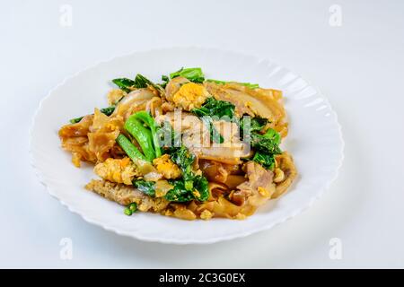 Saltati in padella il riso fresco-farina Tagliatelle con carne di maiale tagliata a fette, uovo e Kale. Quick noodle friggere. Foto Stock