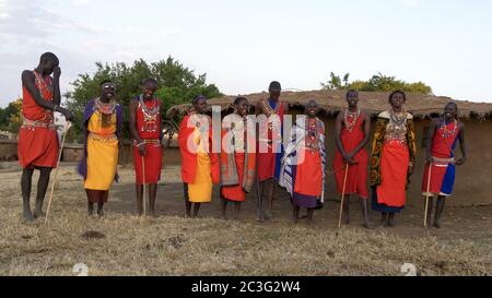 ampia vista di un gruppo di dieci donne e uomini maasai che cantano Foto Stock