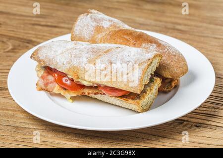 Aprire il panino con prosciutto, mozzarella e pomodori sul tavolo da cucina, fondale focus Foto Stock