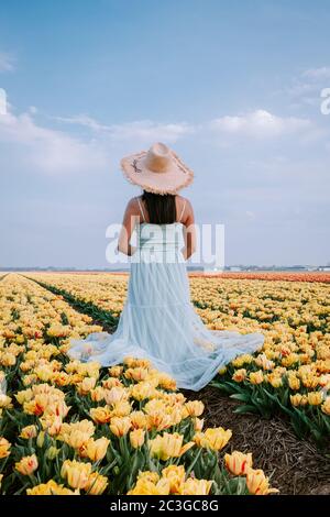 Coppia uomini e donne in campo di fiori nei Paesi Bassi durante la primavera, campo tulipani rosso arancio vicino Noordoostpolder Flevoland NE Foto Stock