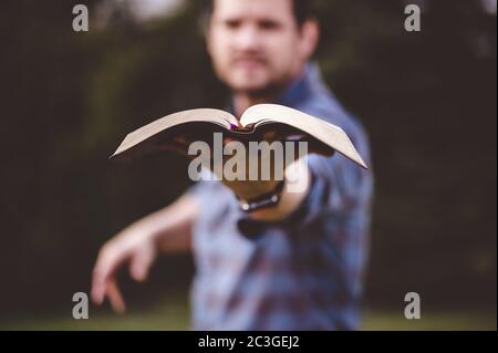 Maschio che tiene la Bibbia Santa e la predica con a. molto entusiasmo Foto Stock