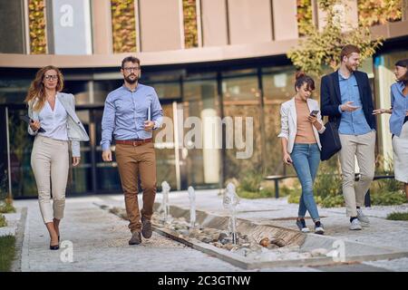 i partner caucasici d'affari camminano e parlano di fronte alla costruzione di affari Foto Stock