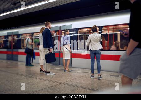 giovani uomini d'affari alla stazione della metropolitana in attesa di un treno. Concetto di tempo Foto Stock