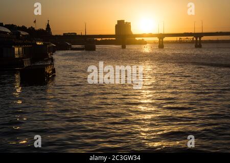 Ricco tramonto estivo colorato a Dnepropetrovsk (Dnept, Dnipro) nel mese di giugno con Parus cantiere incompiuto + due ponti sul fiume nello skyline Foto Stock